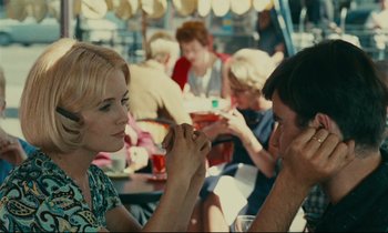 Movie still from “Happiness” (1965), directed by Agnès Varda – A woman and a man are sitting at a table; Medium shot, Over the shoulder angle