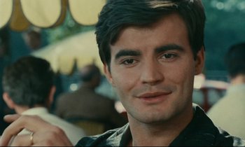 Movie still from “Happiness” (1965), directed by Agnès Varda – A person wearing a black shirt; Close Up shot, Over the shoulder angle