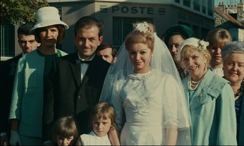 Movie still from “Happiness” (1965), directed by Agnès Varda – A group of people standing next to each other; Medium shot, Low angle