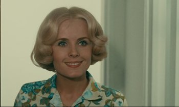 Movie still from “Happiness” (1965), directed by Agnès Varda – A person wearing a floral shirt; Close Up shot, Over the shoulder angle