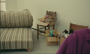 Movie still from “Happiness” (1965), directed by Agnès Varda – A living room filled with furniture next to a table; Wide shot, High angle