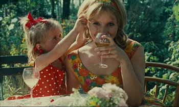 Movie still from “Happiness” (1965), directed by Agnès Varda – A woman and a child drinking wine at a table; Close Up shot, Over the shoulder angle
