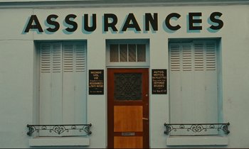 Movie still from “Happiness” (1965), directed by Agnès Varda – A building that has a sign on the side of it; Extreme Wide shot, High angle