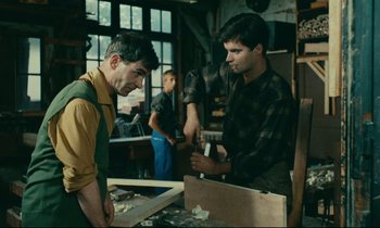 Movie still from “Happiness” (1965), directed by Agnès Varda – Two men working in a wood working shop; Medium shot, Over the shoulder angle