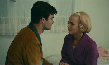 Movie still from “Happiness” (1965), directed by Agnès Varda – A man and a woman sitting next to each other in a room; Close Up shot, Over the shoulder angle