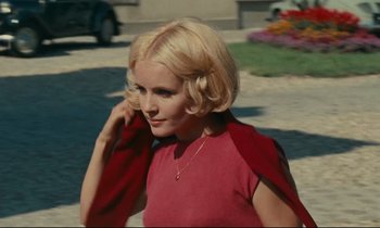 Movie still from “Happiness” (1965), directed by Agnès Varda – A woman with blonde hair wearing a red dress; Close Up shot, High angle