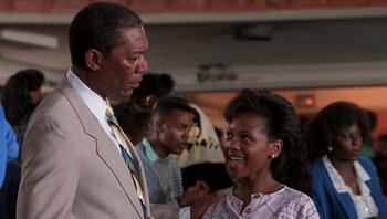 Movie still from “Lean on Me” (1989), directed by John G. Avildsen – A man and a woman talking to each other; Medium shot, Low angle