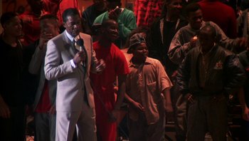 Movie still from “Lean on Me” (1989), directed by John G. Avildsen – A group of men standing next to each other on a stage; Medium shot, High angle