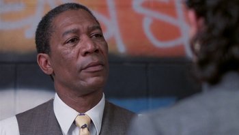 Movie still from “Lean on Me” (1989), directed by John G. Avildsen – A man in a suit and tie looking to his left; Close Up shot, Low angle