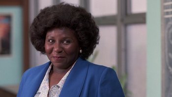 Movie still from “Lean on Me” (1989), directed by John G. Avildsen – An older woman in a blue jacket looks at the camera; Close Up shot, Low angle