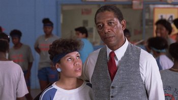 Movie still from “Lean on Me” (1989), directed by John G. Avildsen – A man and a woman standing next to each other in a room; Close Up shot, Low angle