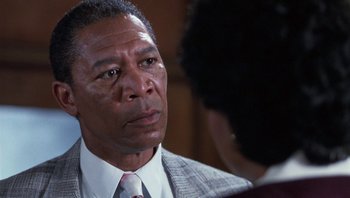 Movie still from “Lean on Me” (1989), directed by John G. Avildsen – An older man in a suit and tie looking to his left; Close Up shot, Over the shoulder angle