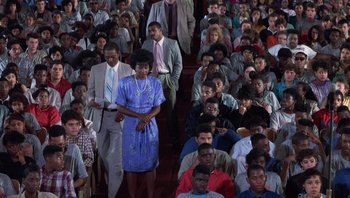 Movie still from “Lean on Me” (1989), directed by John G. Avildsen – A group of people sitting in a room; Wide shot, High angle