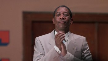 Movie still from “Lean on Me” (1989), directed by John G. Avildsen – A man in a suit and tie clapping his hands; Close Up shot, Low angle