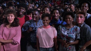 Movie still from “Lean on Me” (1989), directed by John G. Avildsen – A group of people standing in front of each other; Medium shot, High angle
