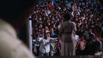 Movie still from “Lean on Me” (1989), directed by John G. Avildsen – A group of people standing in front of an audience; Extreme Wide shot, High angle