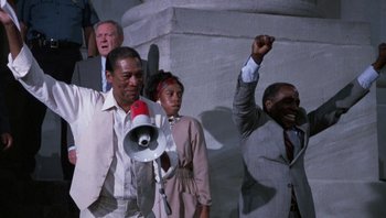 Movie still from “Lean on Me” (1989), directed by John G. Avildsen – A group of people standing next to each other; Medium shot, Low angle