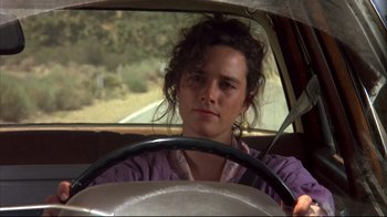 Movie still from “Leatherface: Texas Chainsaw Massacre III” (1990), directed by Jeff Burr – A woman sitting in the driver's seat of a car; Close Up shot, Low angle