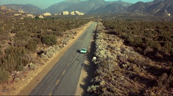 Movie still from “Leatherface: Texas Chainsaw Massacre III” (1990), directed by Jeff Burr – An aerial view of a car driving down a road; Extreme Wide shot, High angle
