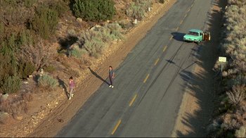 Movie still from “Leatherface: Texas Chainsaw Massacre III” (1990), directed by Jeff Burr – Two people standing on the side of a road; Extreme Wide shot, High angle