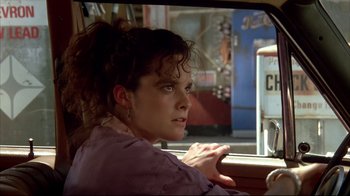 Movie still from “Leatherface: Texas Chainsaw Massacre III” (1990), directed by Jeff Burr – A woman sitting in the driver's seat of a car; Close Up shot, Over the shoulder angle