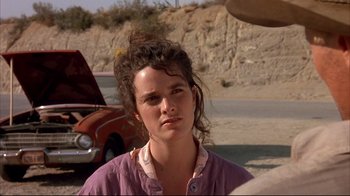 Movie still from “Leatherface: Texas Chainsaw Massacre III” (1990), directed by Jeff Burr – A young woman with her hair pulled back in front of an old car; Close Up shot, Over the shoulder angle
