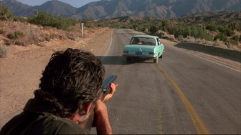 Movie still from “Leatherface: Texas Chainsaw Massacre III” (1990), directed by Jeff Burr – A man taking a picture of a car on the side of the road; Wide shot, High angle