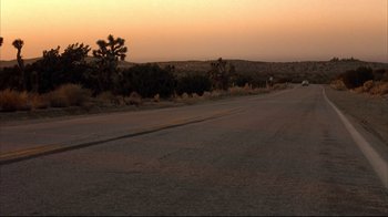 Movie still from “Leatherface: Texas Chainsaw Massacre III” (1990), directed by Jeff Burr – A road that has some trees in the middle of it; Extreme Wide shot, High angle