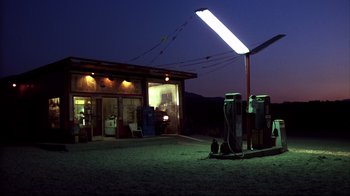 Movie still from “Leatherface: Texas Chainsaw Massacre III” (1990), directed by Jeff Burr – A gas station at night lit by a street light; Extreme Wide shot, Low angle