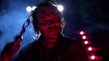 Movie still from “Leatherface: Texas Chainsaw Massacre III” (1990), directed by Jeff Burr – A man in a dark room with lights in the background; Close Up shot, Low angle