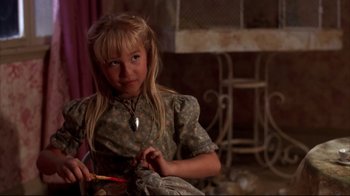 Movie still from “Leatherface: Texas Chainsaw Massacre III” (1990), directed by Jeff Burr – A young girl sitting in front of a chair holding a pair of scissors; Close Up shot, High angle