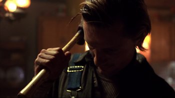 Movie still from “Leatherface: Texas Chainsaw Massacre III” (1990), directed by Jeff Burr – A man holding an axe in his hand; Close Up shot, Over the shoulder angle