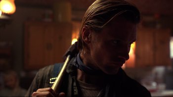 Movie still from “Leatherface: Texas Chainsaw Massacre III” (1990), directed by Jeff Burr – A person holding a stick in a dark room; Close Up shot, Low angle