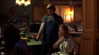 Movie still from “Leatherface: Texas Chainsaw Massacre III” (1990), directed by Jeff Burr – A man and a woman in a kitchen holding a knife; Medium shot, Over the shoulder angle
