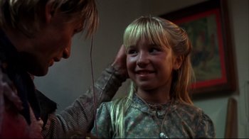 Movie still from “Leatherface: Texas Chainsaw Massacre III” (1990), directed by Jeff Burr – A young girl getting her hair done by a woman; Close Up shot, Over the shoulder angle