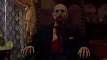 Movie still from “Leatherface: Texas Chainsaw Massacre III” (1990), directed by Jeff Burr – A man in a suit and tie with blood on his face; Medium shot, High angle