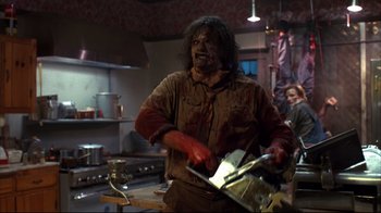 Movie still from “Leatherface: Texas Chainsaw Massacre III” (1990), directed by Jeff Burr – A man with a bloody face holding a knife in a kitchen; Medium shot, Low angle
