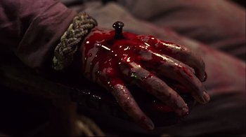 Movie still from “Leatherface: Texas Chainsaw Massacre III” (1990), directed by Jeff Burr – A hand with blood on it and a needle in it; Extreme Close Up shot, High angle