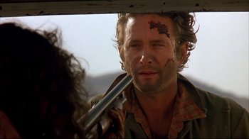 Movie still from “Leatherface: Texas Chainsaw Massacre III” (1990), directed by Jeff Burr – A man holding a metal pipe with blood on his face; Close Up shot, Over the shoulder angle