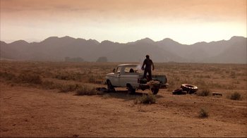 Movie still from “Leatherface: Texas Chainsaw Massacre III” (1990), directed by Jeff Burr – A man standing on the back of an old pick - up truck; Extreme Wide shot, Low angle