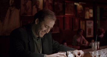 Movie still from “Leaving Las Vegas” (1995), directed by Mike Figgis – A man sitting at a table looking at a cell phone; Close Up shot, Low angle