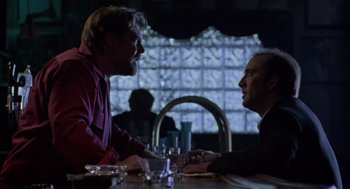 Movie still from “Leaving Las Vegas” (1995), directed by Mike Figgis – Two men sitting at a table talking to each other; Medium shot, Over the shoulder angle