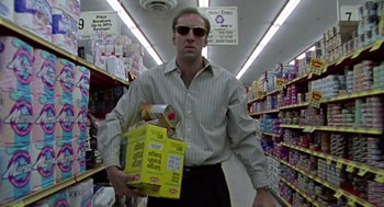 Movie still from “Leaving Las Vegas” (1995), directed by Mike Figgis – A man in sunglasses holding a box in a grocery store aisle; Medium shot, Low angle