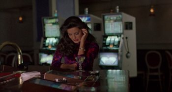 Movie still from “Leaving Las Vegas” (1995), directed by Mike Figgis – A woman sitting at a table in front of slot machines; Medium shot, High angle