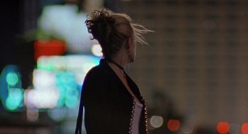 Movie still from “Leaving Las Vegas” (1995), directed by Mike Figgis – A woman is walking down the street at night; Medium shot, Over the shoulder angle