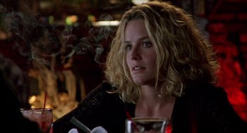 Movie still from “Leaving Las Vegas” (1995), directed by Mike Figgis – A woman sitting at a table smoking a cigarette; Close Up shot, Over the shoulder angle