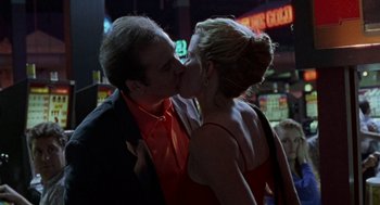 Movie still from “Leaving Las Vegas” (1995), directed by Mike Figgis – A man and a woman kissing each other in front of a neon sign; Close Up shot, Low angle