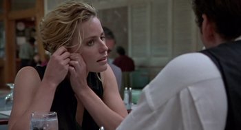 Movie still from “Leaving Las Vegas” (1995), directed by Mike Figgis – A woman sitting in front of a mirror putting on her earrings; Close Up shot, Over the shoulder angle