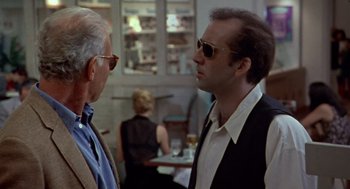Movie still from “Leaving Las Vegas” (1995), directed by Mike Figgis – A man wearing sunglasses talking to another man; Close Up shot, Over the shoulder angle