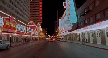 Movie still from “Leaving Las Vegas” (1995), directed by Mike Figgis – A city street at night lit up by neon signs; Extreme Wide shot, High angle